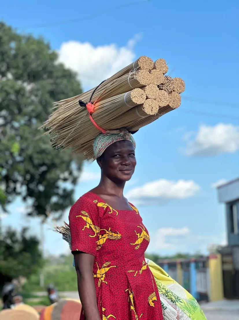 A straw vendor carrying bundles of basket straw on her head