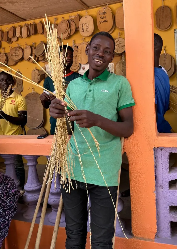 A basket maker holding long prepared strands of straw