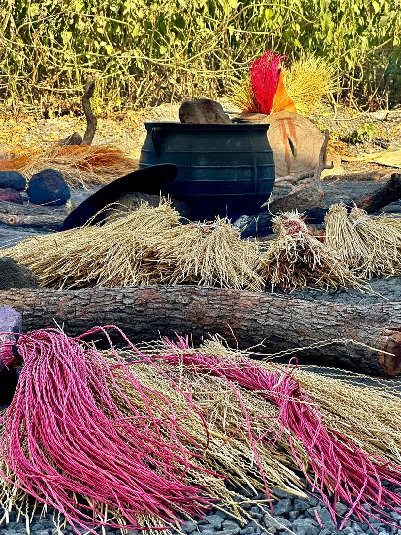 Dyed straw bundles beside dyeing pots