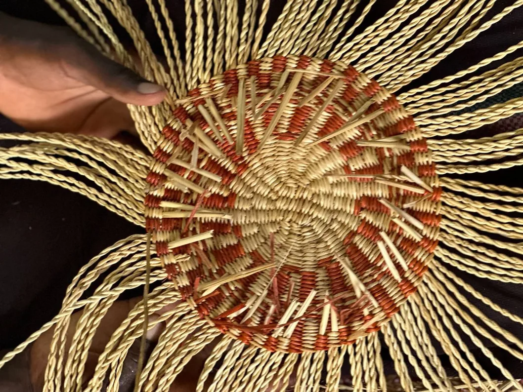 Close view of the centre of a basket base being woven