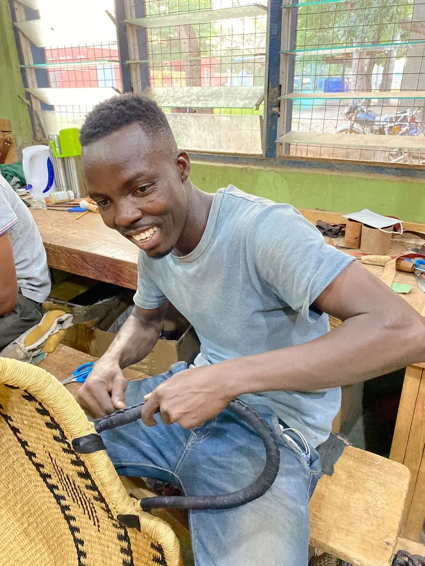 A leather worker finishing a leather covered basket handle